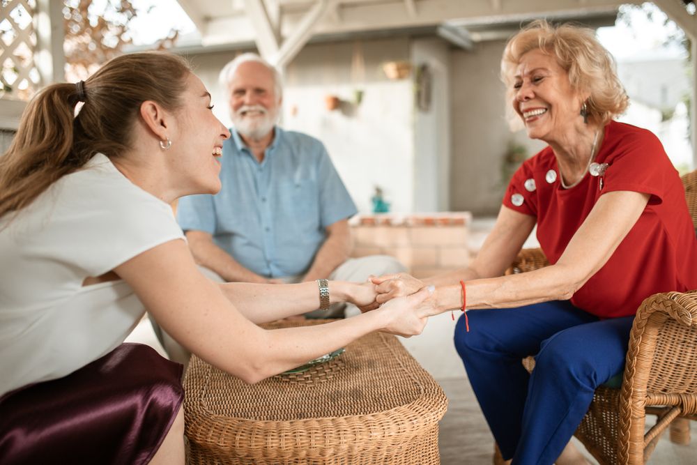 A younger woman and an older couple enjoying a friendly conversation